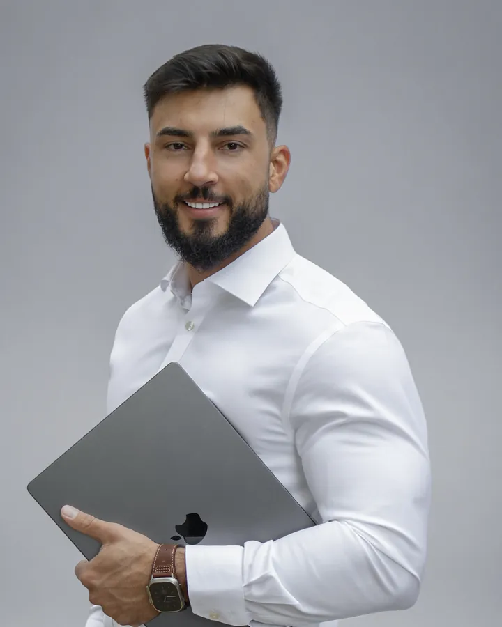 Eduard Vlase, founder of MyCoach Ed, holding a laptop